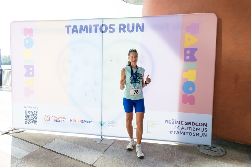 A runner with her medal at the photo wall