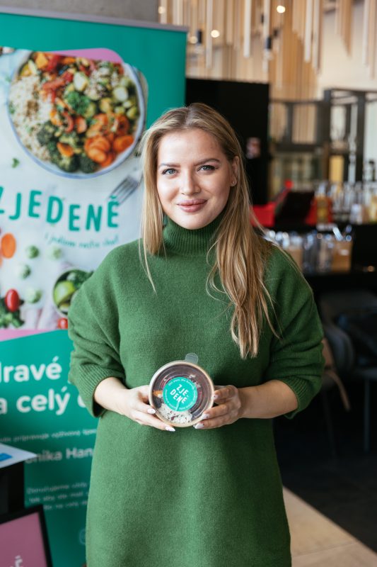 A guest with a Zjedené bowl at the banner